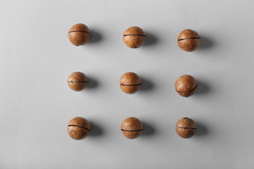 Tasty macadamia nuts on light background