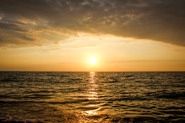Golden, Fiery sunset on the Black Sea, on the beach. Coast, stones, waves, sun, beautiful sky, clouds. August, Batumi, Georgia. Water, ease, game.