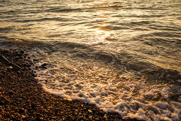 Golden, Fiery sunset on the Black Sea, on the beach. Coast, stones, waves, sun, beautiful sky, clouds. August, Batumi, Georgia. Water, ease, game.