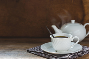 white tea set on wooden table, hot drink with steam