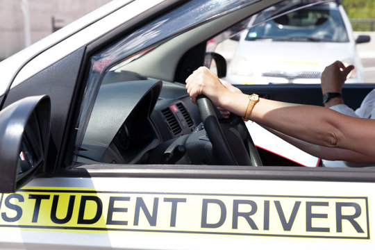 Learner driver student holding steering wheel during driving lesson