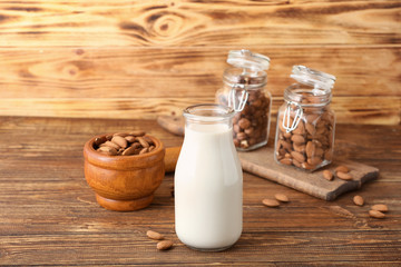 Bottle of tasty nut milk on wooden table