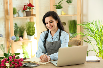 Beautiful female florist working at table