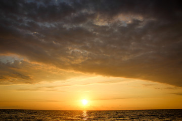 Naklejka na ściany i meble Golden, Fiery sunset on the Black Sea, on the beach. Coast, stones, waves, sun, beautiful sky, clouds. August, Batumi, Georgia. Water, ease, game.