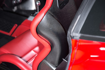 Close up of carbon fibre red leather car seat