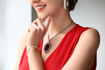 Young woman with beautiful jewelry indoors, closeup