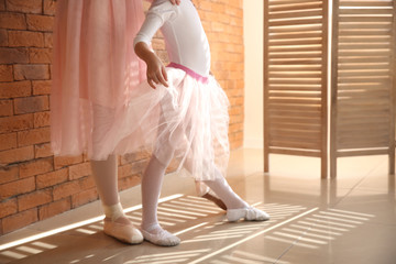 Little ballerina training with coach in dance studio