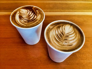 Two lattes in to-go paper coffee cups