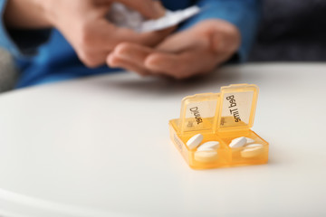 Container with pills on table