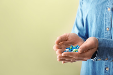 Woman with pills on color background, closeup