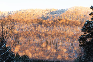 Ural mountains in the evening light. Golden sunset in the mountains. Winter beauty on the slopes.