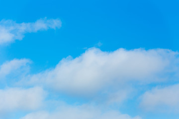 Horizontal photo of winter blue clear sky background with white layered clouds without sun