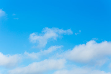 Horizontal photo of winter blue clear sky background with white layered clouds without sun
