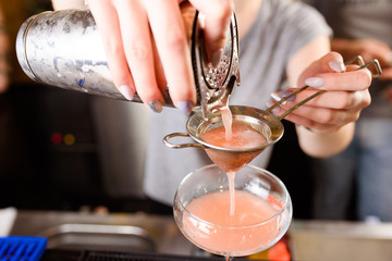 Expert barman is making cocktail at night club, Barman holds a cocktail in his hand. No face. Selective focus