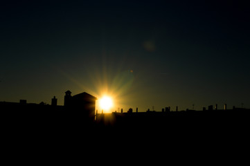 Fototapeta premium Sol que se esconde tras los edificios
