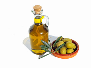 Olive oil in a glass bottle and terracotta dish with olives