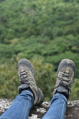 Adventure & outdoor activity concept :  The part of trekking shoes  with forest background 