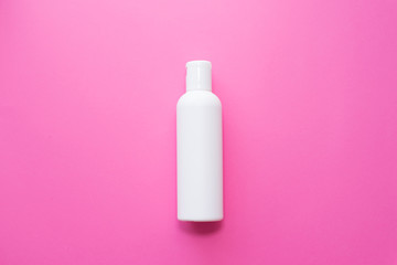 white Plastic bottle on a pink background. skin, body care. copy space. place for text