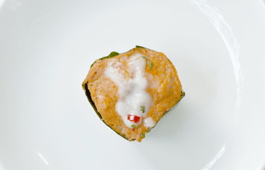steamed fish with curry paste in banana leaf tray on plate