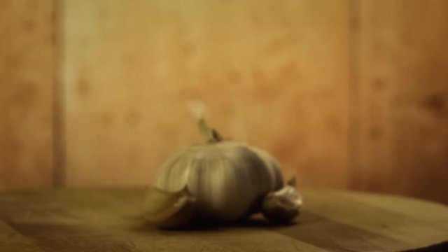 Head of garlic and cloves of garlic on wodden desk. Rotating, turntable shot. Still life