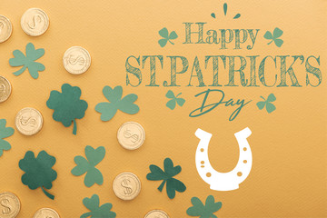 top view of golden coins with dollar signs near shamrocks and happy st patricks day lettering on orange background