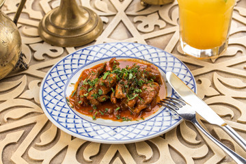 Meat stew with greens on oriental table background