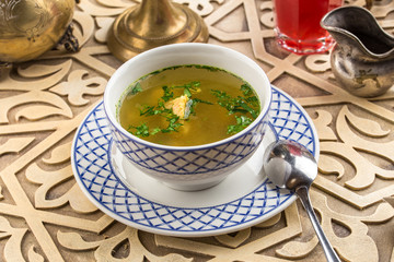 Bowl of fish soup on oriental table background