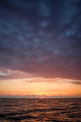 Fototapeta na wymiar Golden, Fiery sunset on the Black Sea, on the beach. Coast, stones, waves, sun, beautiful sky, clouds. August, Batumi, Georgia. Water, lightness, play. Pink, lilac, crimson