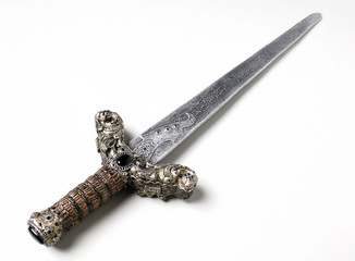 Closeup of vintage metal sword decorated with gems on white background
