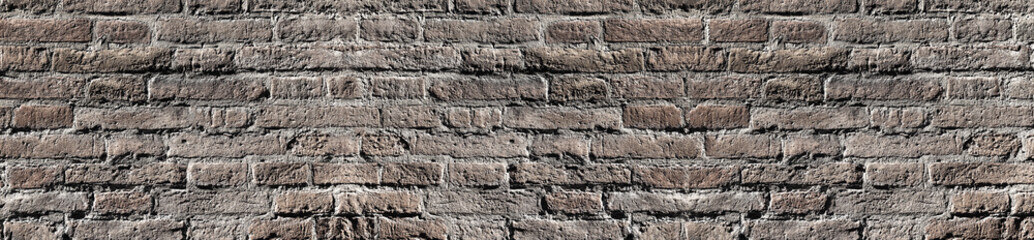 Bleached vintage brick wall texture in contrast lighting for design. Panoramic background for text and image.