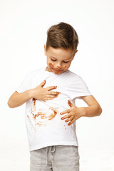 little boy with face and hands in chocolate 