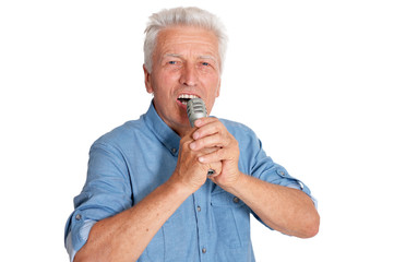 Senior man singing into microphone on white background