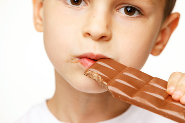 little beautiful boy eating chocolate studio shot 