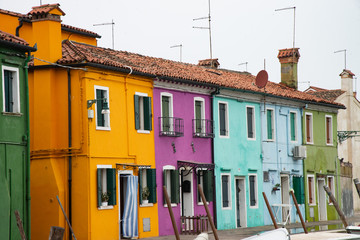 Fototapeta na wymiar Geometry of windows and doors in the colorful houses of the island of Burano, Venice, Italy Features old multicolored houses.