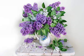A large bouquet of lilac in a white vase on a white background.Spring still life