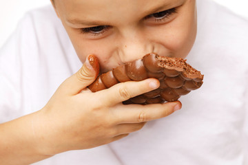 little beautiful boy eating chocolate studio shot 