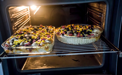 Homemade pizzas in oven. Process of making pizza art. Fresh original raw pizza preparation. Pizza made with plenty of ingredients. Beginnnig of a meal process. Heap / pile of olives, peppers, sausages