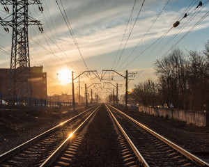 railway rails in the evening in the light of the sun at sunset in early spring