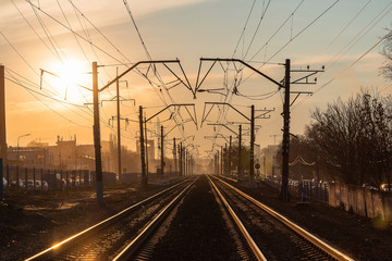 Fototapeta na wymiar railway rails in the evening in the light of the sun at sunset in early spring