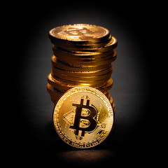Cryptocurrency Bitcoin in front of a Pile of Coins