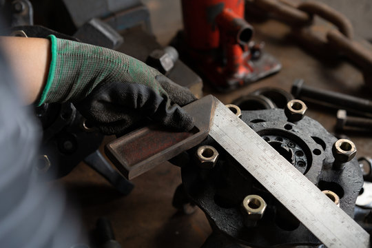 Female Engineer Hand Using Right Angle Square To Measure Mechanical Part - Hands Of Woman Mechanic Using A Measuring Device On A Automotive Wheel Hub