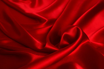 Red silk or satin luxury fabric texture can use as abstract background. Top view.