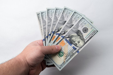  Man's hand holding many hundred dollar bills. Business concept. Finance concept.