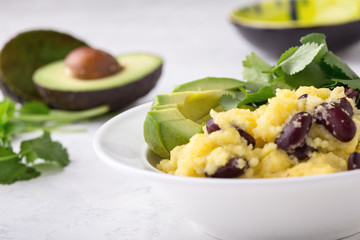 Healthy vegan brunch bowl with  grits, black beans,  avocado