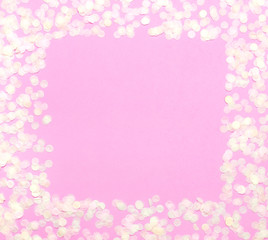 Frame of paper round confetti with clear square in the middle on pastel pink background top view Flat lay. Festive holiday background, concept of party, birthday, christmas or new year