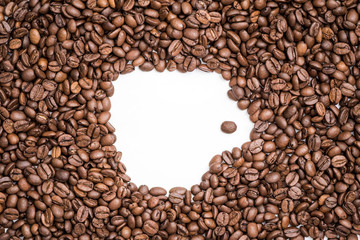 Shape of white coffee cup  in the middle of freshly roasted coffee beans texture.Copy space.