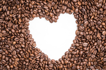 Shape of white heart  in the middle of freshly roasted coffee beans texture.Copy space.