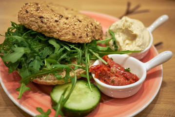 Vegetarian bagel with rocket, hummus and tomatoes