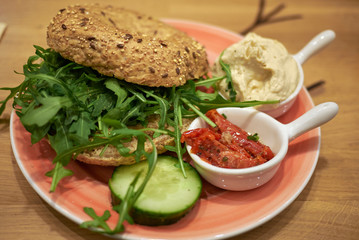 Vegetarian bagel with rocket, hummus and tomatoes