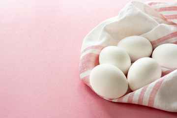 white eggs on a towel breakfast for family in the country, on a pink background